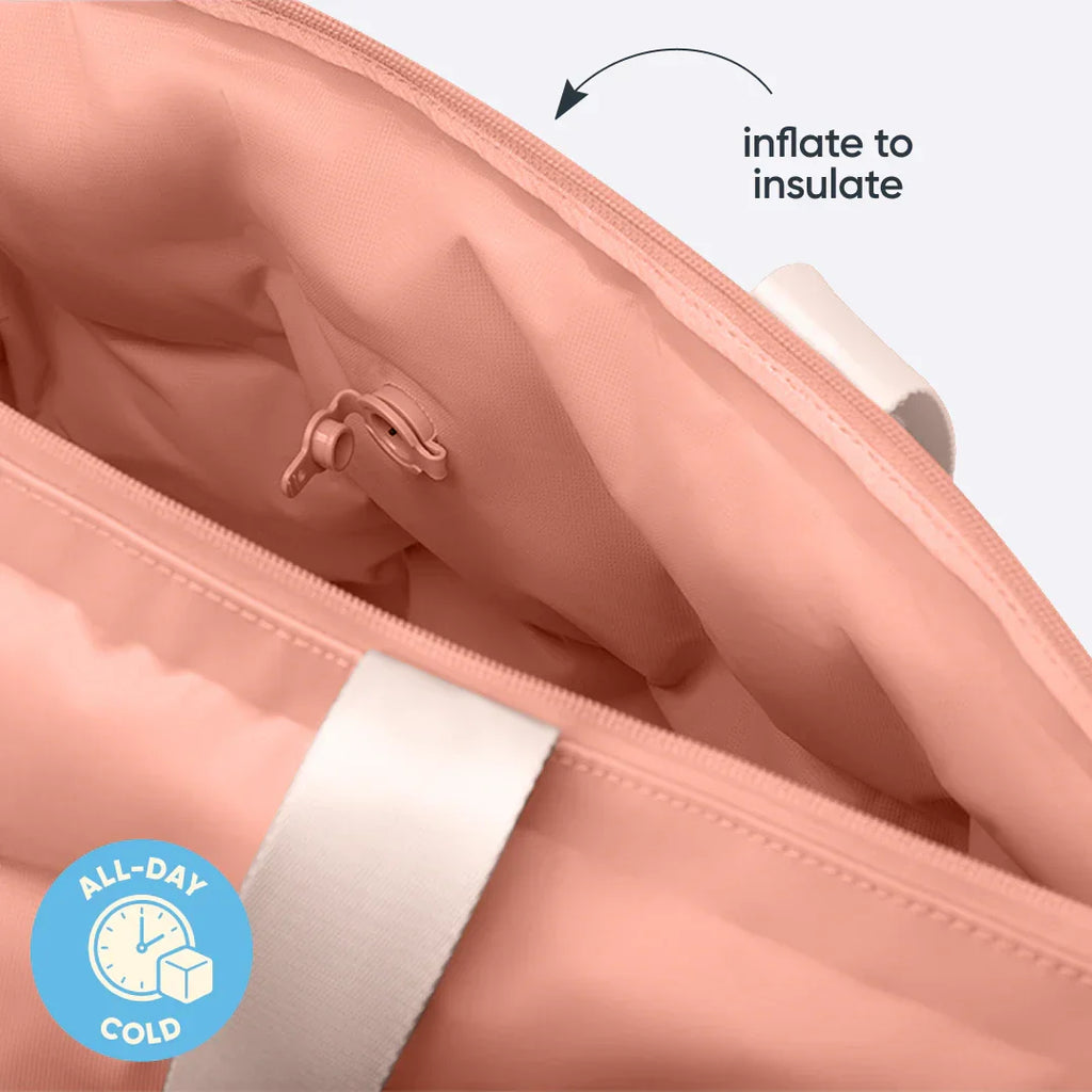 Owala Cloud tote in Rosewood shown deflated and folded flat, coral pink body with blush owala-tape handles, with text overlay reading "deflates for easy storage"
